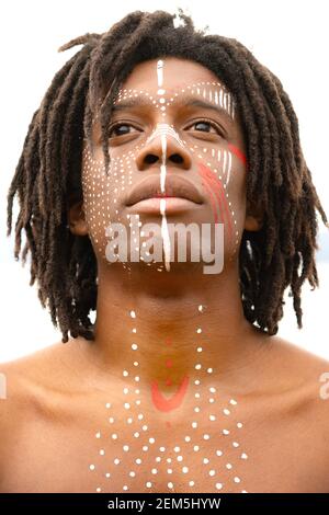 Un uomo con dreadlock e pittura del viso Foto Stock