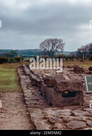 Corbridge vicino Hexham, Northumberland, Inghilterra - rovine di un grande forte romano Coria, una guarnigione che custodisce il Muro di Adriano. Elementi di un acquedotto. Scansione di archivio da un vetrino. Giugno 1974. Foto Stock