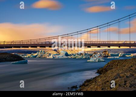 Ponte stradale sulla laguna glaciale di Jokulsarlon in Islanda al tramonto Foto Stock