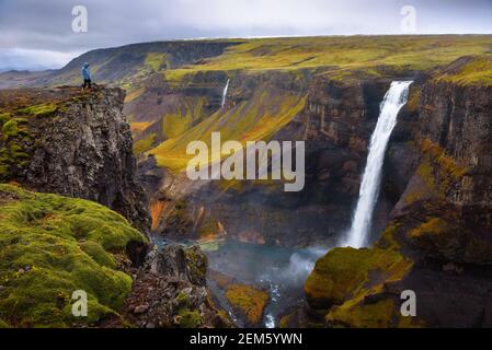 Escursionista in piedi al bordo della cascata Haifoss in Islanda Foto Stock