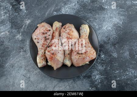 Primo piano foto delle zampe di pollo crudo marinato in grigio sfondo Foto Stock