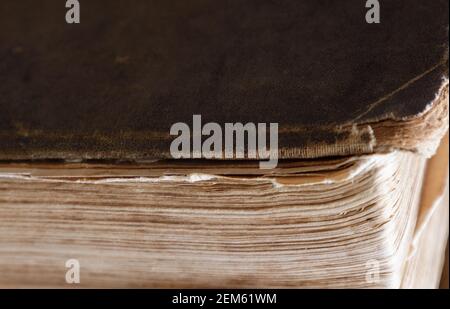 primo piano dell'angolo di un vecchio libro con i bordi sfilacciati della copertina. Foto Stock