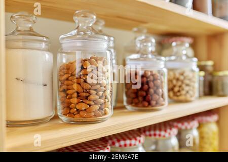 Scaffali in legno aperto in cucina con vasi e piante di casa, dispensa.  Vista sulla cucina. Messa a fuoco selettiva. Soggiorno sostenibile cucina  eco-friendly Foto stock - Alamy