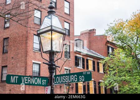 Primo piano di una lampada a gas tradizionale con Cartelli stradali nel quartiere storico di Beacon Hill in Centro di Boston Foto Stock