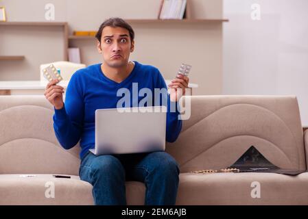 Giovane uomo che soffre a casa Foto Stock