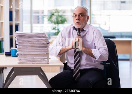 Il vecchio dipendente dell'uomo d'affari non è soddisfatto del lavoro eccessivo Foto Stock