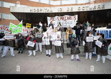 Madrid, Spagna. 24 Feb 2021. Operatori sanitari in possesso di cartelli che esprimono la loro opinione all'ingresso dell'Ospedale 12 de Octubre durante la manifestazione a favore della sanità pubblica a Madrid. Credit: SOPA Images Limited/Alamy Live News Foto Stock