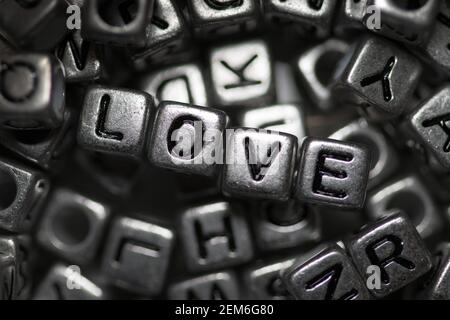 Primo piano della parola amore scritto in argento perline metalliche Foto Stock