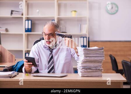 Il vecchio dipendente maschio è insoddisfatto del lavoro eccessivo sul posto di lavoro Foto Stock