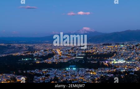 Cielo azzurro ora notte città di Quito con il vulcano Cayambe, Ecuador. Foto Stock