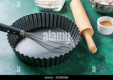 Forma di cottura per torte, spilla e frusta su sfondo colorato, primo piano Foto Stock