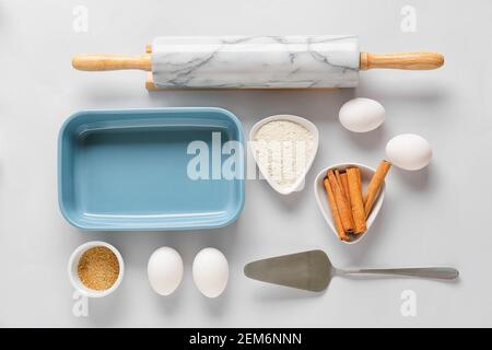 Set di utensili da cucina e ingredienti per la preparazione di panetteria sfondo chiaro Foto Stock