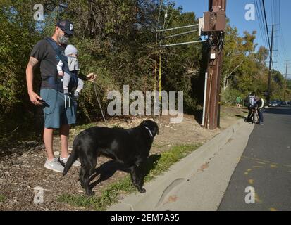 Rolling Hills Estates, Stati Uniti. 24 Feb 2021. Il residente locale Enrique Santana porta il suo figlio di sei mesi Alister in una passeggiata vicino alla zona dove la leggenda del golf Tiger Woods ha rotolato la sua auto dopo aver attraversato una mediana a Rolling Hills Estates, California, mercoledì 24 febbraio 2021. Gli esperti dicono che Tiger Woods ha una lunga strada per andare nel suo processo di recupero dalle ferite rotte della gamba, della caviglia e del piede ha sostenuto in un incidente di auto Martedì nella California del Sud. Foto di Jim Ruymen/UPI Credit: UPI/Alamy Live News Foto Stock