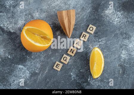 Frutta arancione tagliata con alesatore di legno Foto Stock