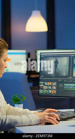 Videografo che lavora al computer dall'ufficio aziendale, editing video e audio di notte. Creazione di contenuti utilizzando dispositivi professionali moderna tecnologia di elaborazione wireless montaggio film. Foto Stock