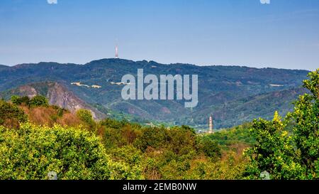 Un paesaggio montano con un camino nella valle e. Un trasmettitore televisivo sulla cima di una collina - Bukova Torre della TV di Hora Foto Stock