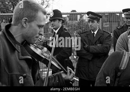 I giocatori fiddle hanno guardato dagli ufficiali della polizia metropolitana ad una protesta contro le strade a Wanstead, Londra Est, come parte della campagna No M11 link Road di azione diretta contro la costruzione della strada M11 link Road nel 1994 Foto Stock