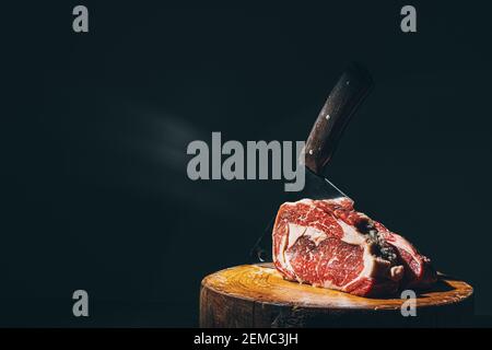 coltello macellaio e carne su un tagliere Foto Stock