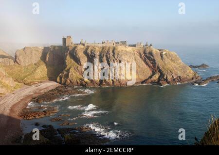 Dunnottar Castle, nella nebbia mattutina, dall'altra parte della Old Hall Bay, vicino a Stonehaven, Aberdeenshire, Scozia Foto Stock