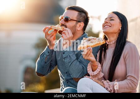 Uomo e donna che mangiano pizza.Pizza tempo. Fast food.Unhealthy concetto. Foto Stock