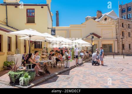 Le persone cenano all'aperto sotto ombrelli all'ombra in un caldo giorno estivo di Sydney. Il governo del NSW ha incoraggiato la ristorazione all'aperto per ridurre il rischio di virus Corona Foto Stock