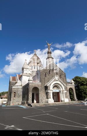 Vista frontale dell'esterno del Santuario del Sacre Coeur de Balata a Forte de France, Martinica contro un cielo blu chiaro con una nuvola bianca Foto Stock