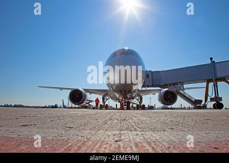 Imbarco dei passeggeri sull'aereo attraverso il ponte d'imbarco. L'aereo atterra all'aeroporto internazionale. Carico bagagli. Aereo bianco. Terminale Foto Stock