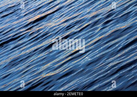 Ondulazione della superficie dell'acqua con riflesso della luce solare. Foto a colori, sfondo N. 4 Foto Stock