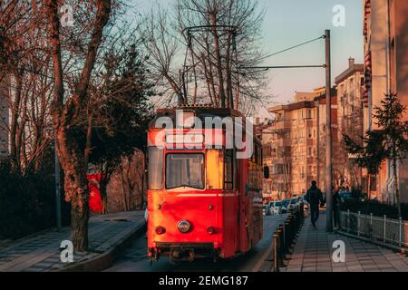 Vecchio tram nostalgico che attraversa le strade di Kadikoy sul lato asiatico di Istanbul. Vista del tramonto. Foto Stock