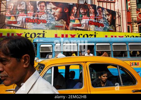 Scena di strada con un taxi giallo Ambassador, autobus e persone nel centro di Kolkata, India. Foto Stock