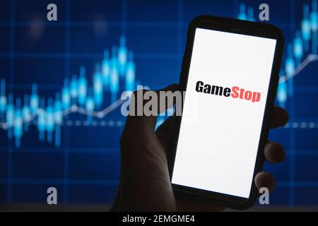 LONDRA, UK - Febbraio 2021: Logo Gamestop davanti al grafico dei prezzi di borsa Foto Stock