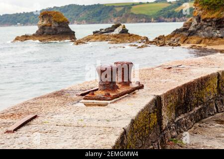 Old Rusty ormeggio pilastri utilizzati per ancorare le barche a Charlestown Harbour, Cornovaglia Foto Stock