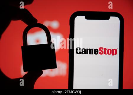 LONDRA, UK - Febbraio 2021: Logo Gamestop e reddit con un lucchetto di sicurezza Foto Stock