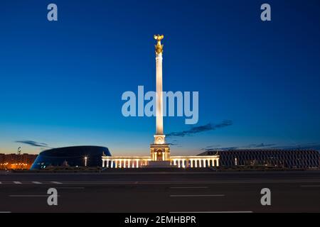 Kazakhstan, Astana, KazakYeli monumento (Paese kazako) con il Palazzo delle Arti Shabyt sulla sinistra e il Palazzo dell'Indipendenza sulla destra Foto Stock