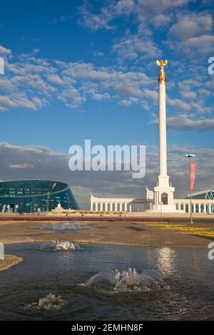 Kazakhstan, Astana, KazakYeli monumento (Paese kazako) con il Palazzo delle Arti Shabyt sulla sinistra Foto Stock