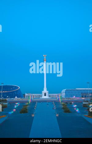 Kazakhstan, Astana, KazakYeli monumento (Paese kazako) con il Palazzo delle Arti Shabyt sulla sinistra e il Palazzo dell'Indipendenza sulla destra Foto Stock