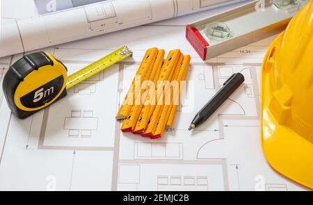 Progetti e lavoratori hardhat colore giallo, edilizia progetto costruzione, cantiere ufficio background. Foto Stock