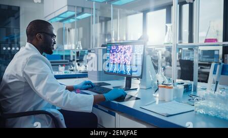 Laboratorio medico moderno: Scienziato maschile, digitando sulla tastiera lavorando sul computer, scren mostra il concetto di ricerca del DNA. Advanced Scientific Lab, Medicina Foto Stock