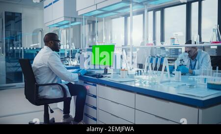 Modern Medical Research Laboratory: Scienziato che lavora sul computer mostrando Green Chroma Key Screen. Laboratorio scientifico, struttura di sviluppo della medicina con Foto Stock