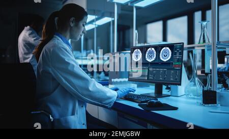 Modern Medical Research Laboratory: Ritratto di scienziato femminile che lavora sul computer, mostrando MRI Brain Scans. Advanced Scientific Lab for Brain Foto Stock