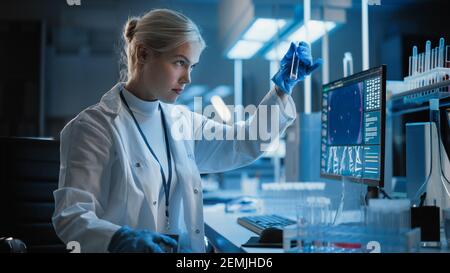 Laboratorio di Ricerca medica: Ritratto di scienziato femminile che lavora su computer, analizzando campione liquido in una fiasca Labolatory. Laboratorio scientifico avanzato Foto Stock