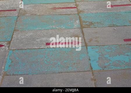 Due frecce direzionali rosse dipinte su una passerella di un bagno (Pesaro, Italia, Europa) Foto Stock