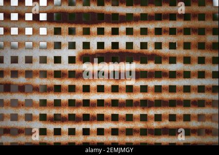 dettaglio di una recinzione in lamiera arrugginita con fori quadrati Foto Stock