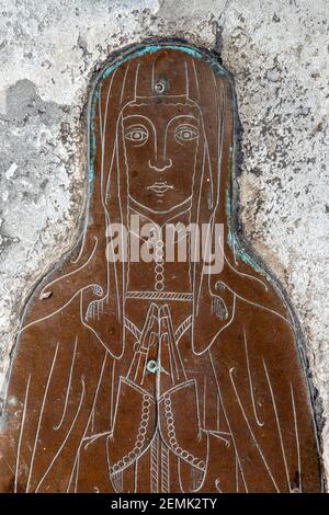 Un dettaglio di un bronzo commemorativo della moglie di un commerciante sconosciuto di lana (c..1400) nella chiesa nella città di Cotswold di Northleach, Gloucestershire UK Foto Stock