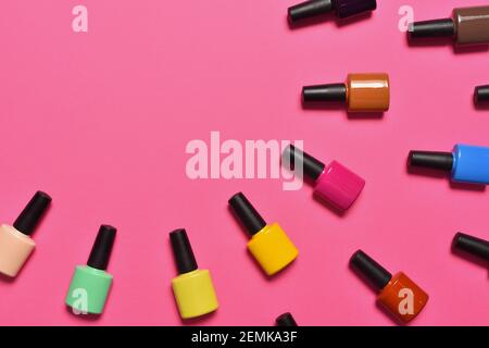 Bottiglie di smalto per unghie su sfondo rosa vista dall'alto con spazio di testo Foto Stock