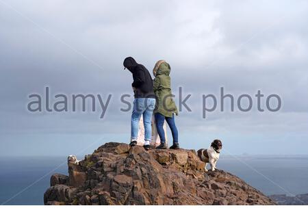 Edimburgo, Scozia, Regno Unito. 25 Febbraio 2021. Persone che si godono la natura all'aperto nel Parco Holyrood con incantesimi soleggiati, vento e qualche pioggia. Sulla cima di Arthurs Seat con una vista sul Forth estuario alla legge di Berwick. Credit: Craig Brown/Alamy Live News Foto Stock