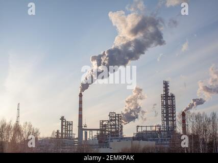 Il lavoro di un impianto petrolchimico. Il fumo proviene dal camino. Foto Stock