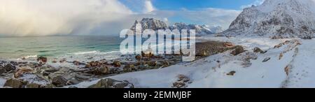 Una vista sulla bellissima spiaggia di Utakliev nelle isole Lofoten durante una tempesta imminente. Piccole figurine di fotografi stanno cercando di coprire Foto Stock
