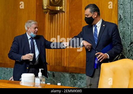 Washington, Stati Uniti. 25 Feb 2021. Lindsey Graham, R-S.C., membro della classifica del Comitato del bilancio del Senato, a sinistra, saluta il Sen. Alex Padilla, D-California, a destra, prima dell'inizio di un'audizione su Capitol Hill a Washington, giovedì 25 febbraio 2021, esaminando i salari delle grandi società redditizie. (Foto di Susan Walsh/Pool/Sipa USA) Credit: Sipa USA/Alamy Live News Foto Stock