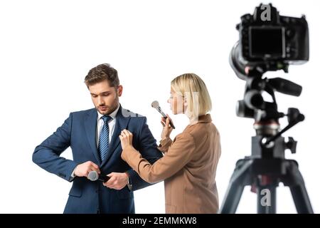 artista di trucco biondo con pennello cosmetico vicino a news ancora che tonica il suo blazer isolato su bianco, primo piano sfocato Foto Stock